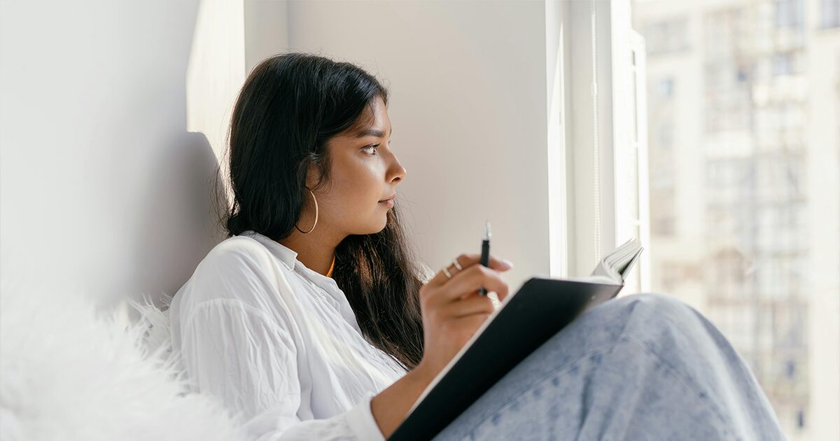 Woman writing down important questions and information to consider before an abortion.